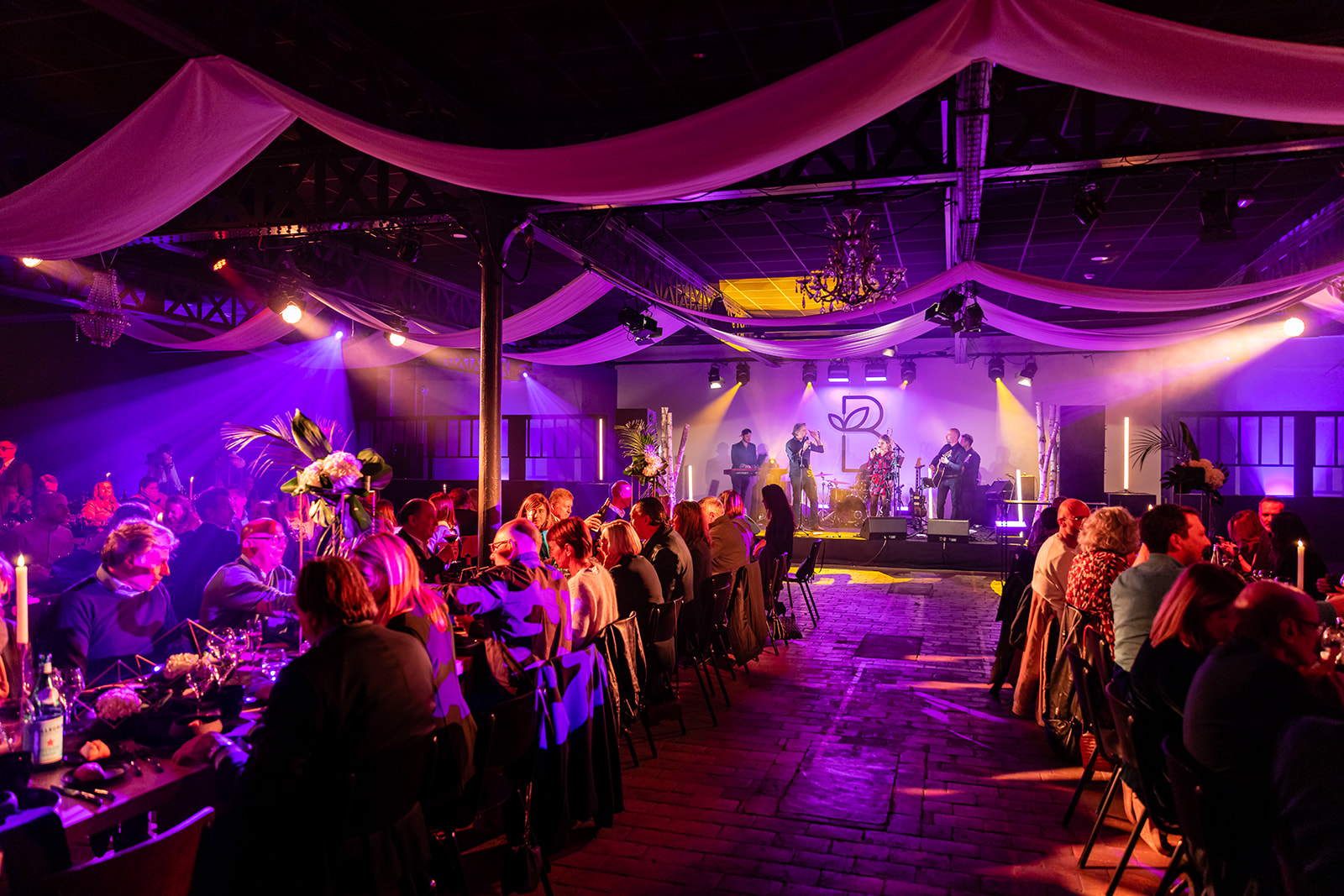 Ambiance de soirée dansante dans une salle aux lumières violettes