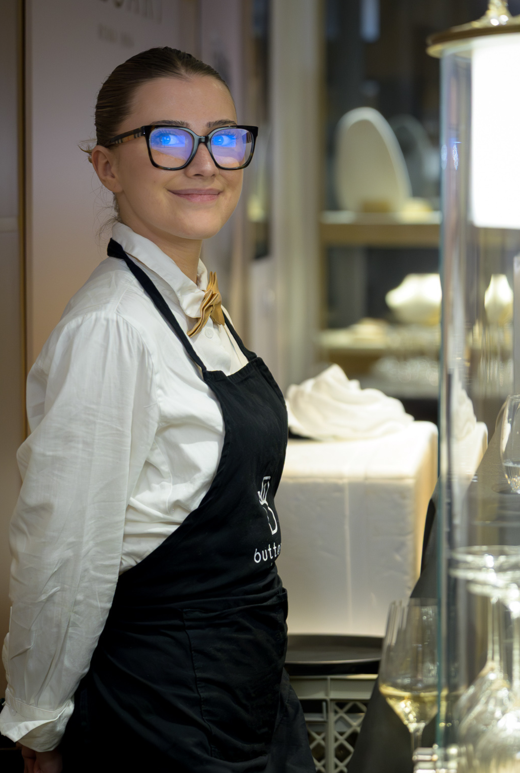 Membre de l'équipe Butterfly en tenue de service devant un buffet