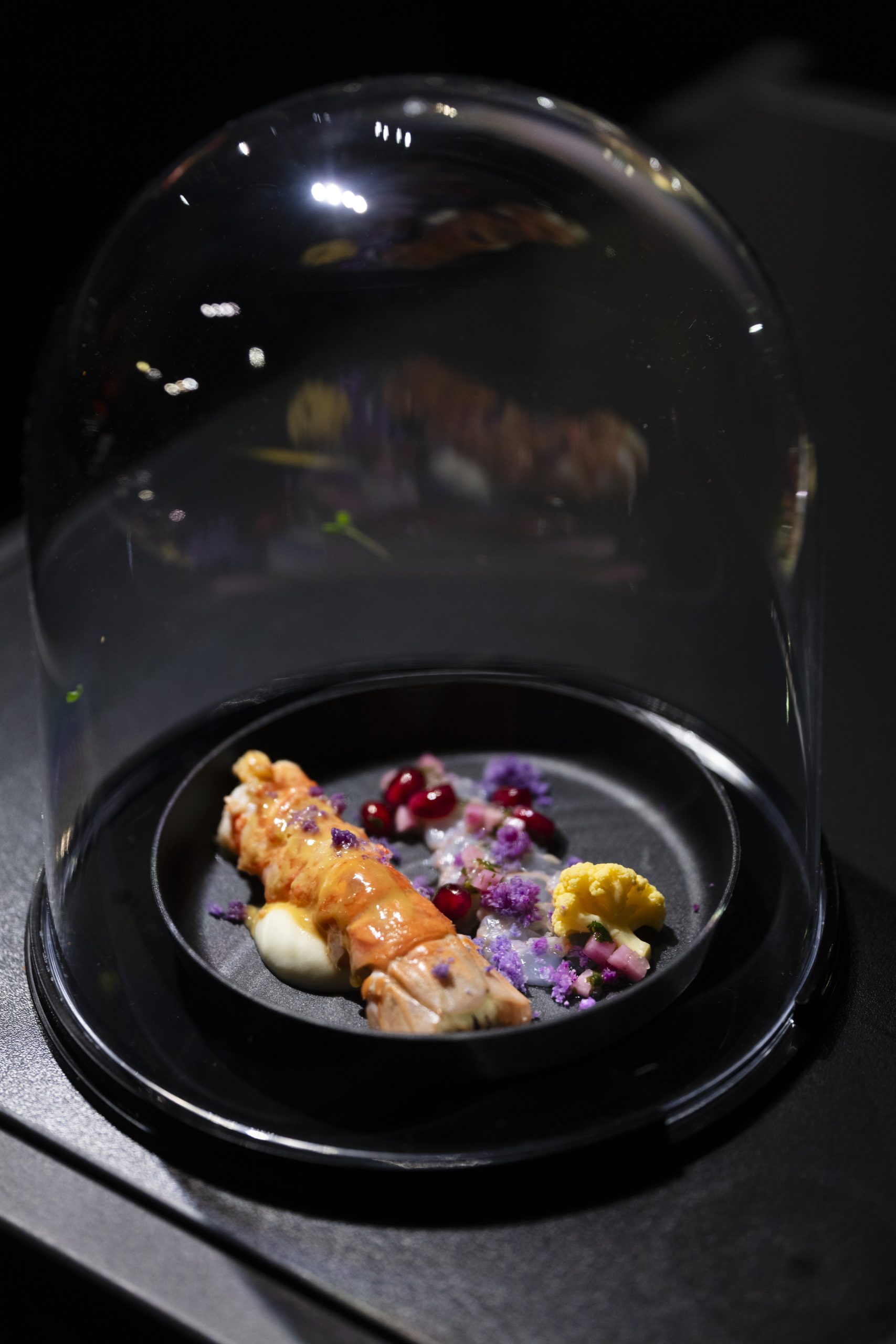 Assiette gastronomique de homard, chou-fleur et grenade servie sous cloche en verre par Butterfly Traiteur
