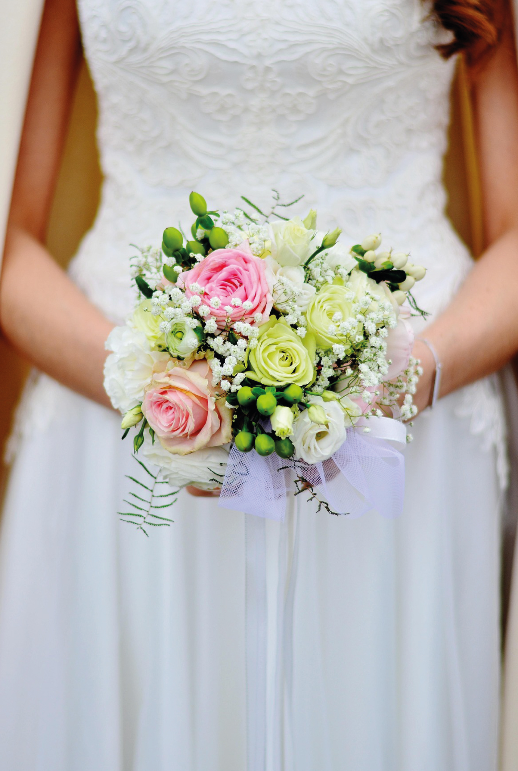 Mariée tenant un bouquet de roses pastel lors d'un mariage organisé par Butterfly Traiteur