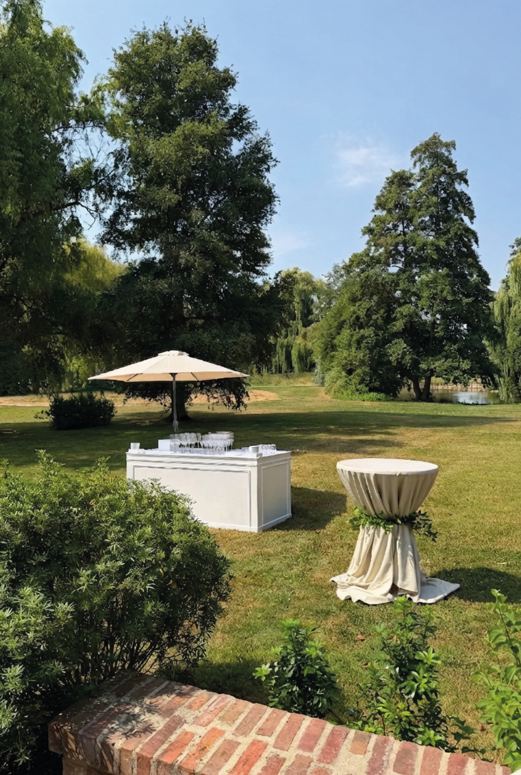 Bar blanc et mange-debout installés dans un parc pour un cocktail en plein air