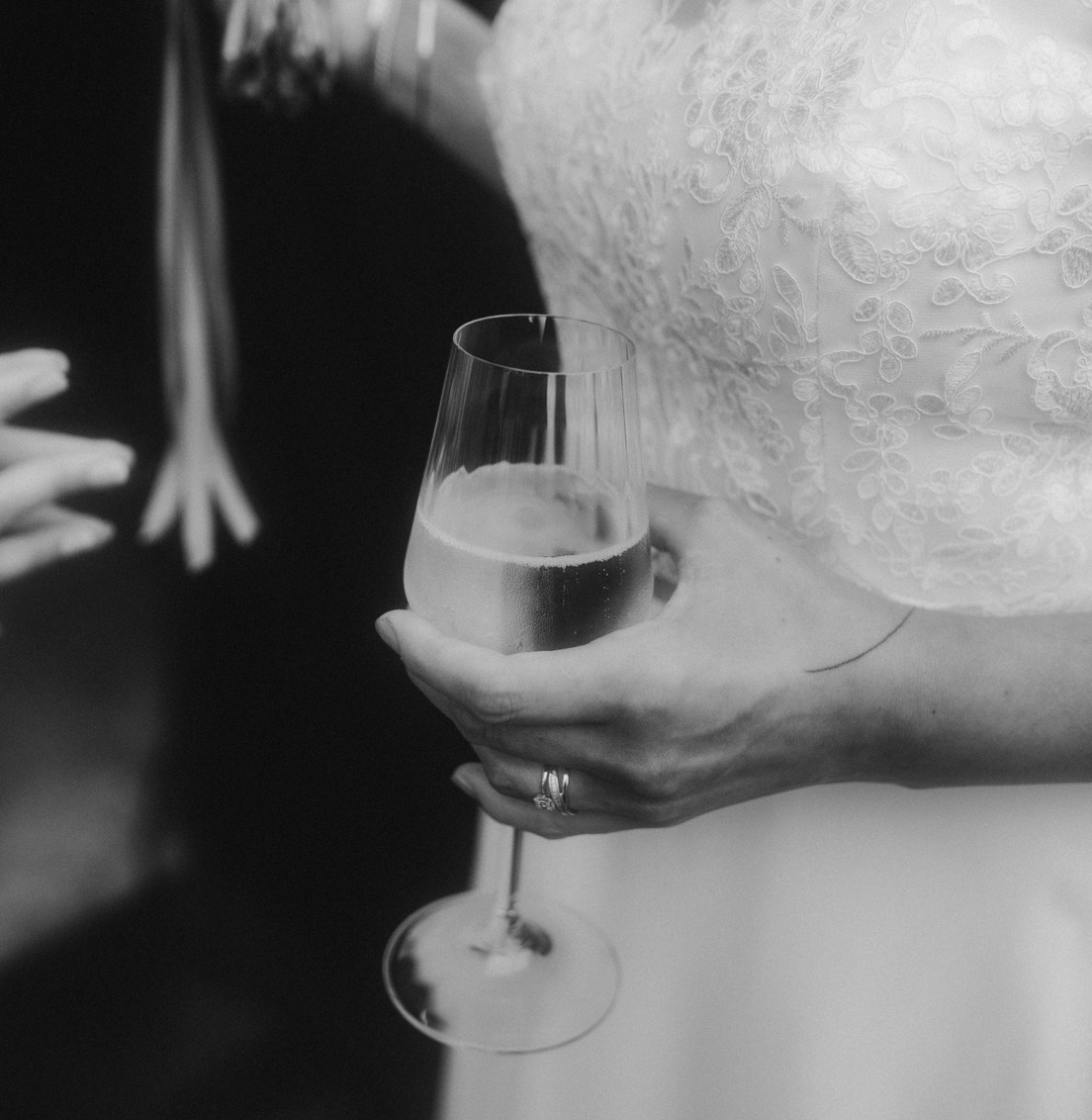 Mariée en robe de dentelle tenant une coupe de champagne pendant le vin d’honneur d’un mariage à Lille